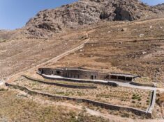 Curving stone walls allow Xerolithi vacation house to merge with Greek island landscape