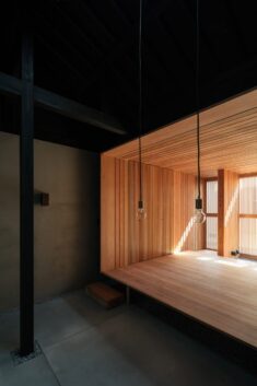 Dark roof brings loftiness to small Kyoto terrace house renovation by Atelier Luke